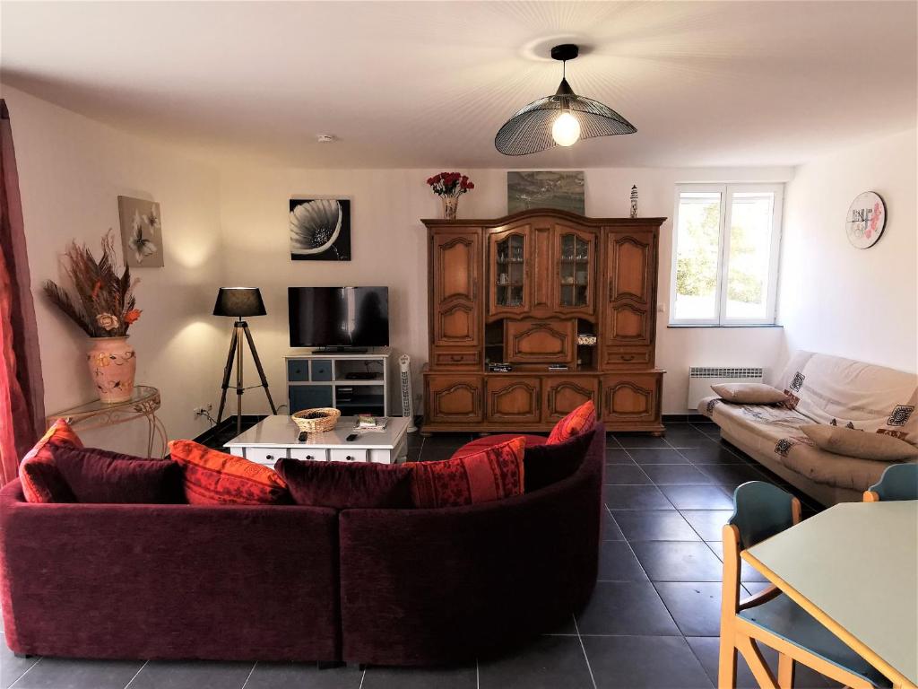 un salon avec un canapé et une télévision dans l'établissement Le Moulin Jodet, à Notre-Dame-de-Monts