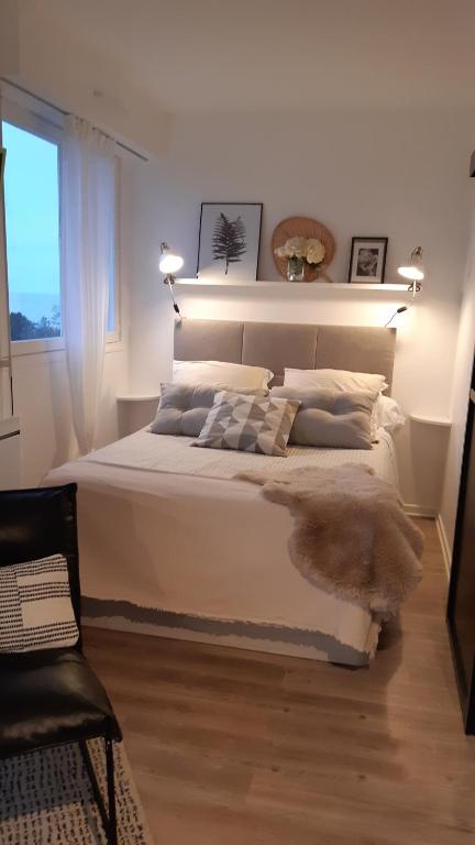 滨海维莱Studio vue panoramique sur mer的卧室里有一张白色的大床和一扇窗户