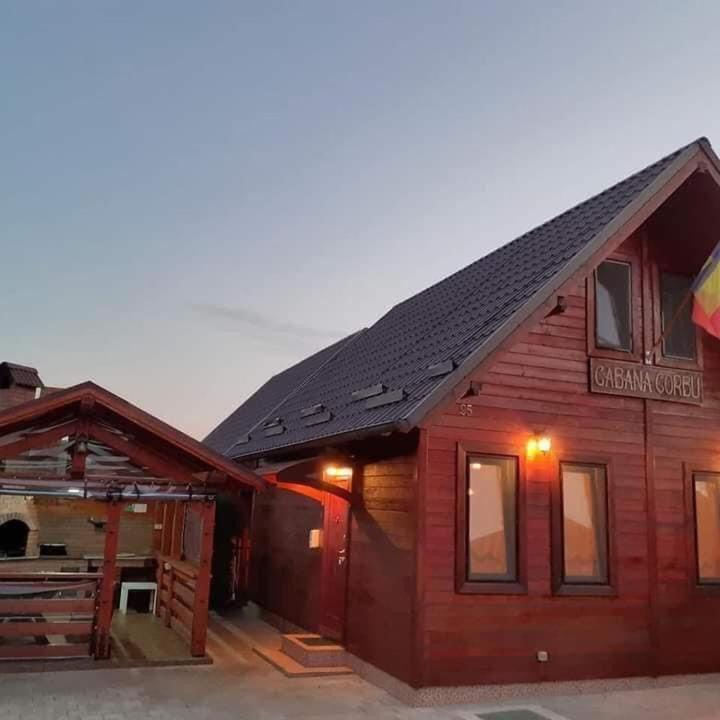 a wooden building with a sign on the side of it at Cabana Corbu Băile Figa in Beclean