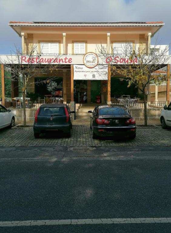 two cars parked in a parking lot in front of a store at Hostel Encostas Do Douro in Marco de Canaveses