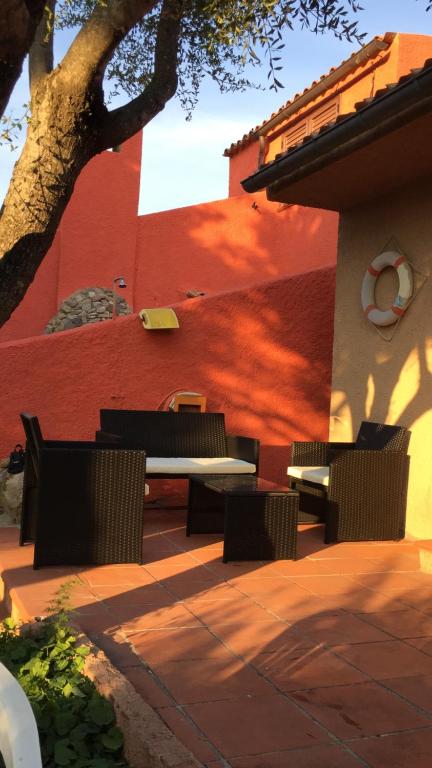 une terrasse avec une table et des chaises devant un bâtiment dans l'établissement Villa Chiara Villetta con giardino IUN 4807, à Porto Pollo