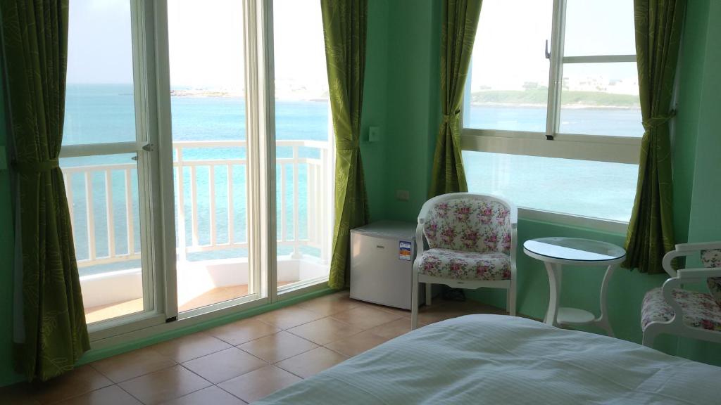 Schlafzimmer mit einem Bett und Meerblick in der Unterkunft Lover's Bay in Magong