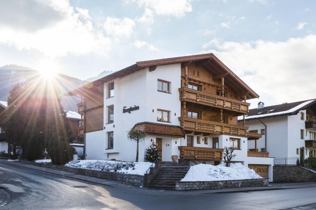 a apartment building with snow on the ground at Pension Bergheim in Reith im Alpbachtal