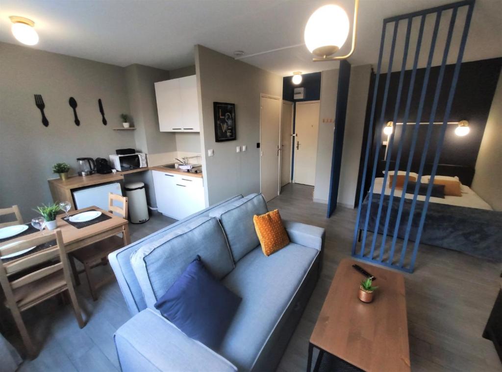 un salon avec un canapé bleu et une cuisine dans l'établissement LE JARDIN DE BAYARD - HYPERCENTRE - GARE, à Toulouse