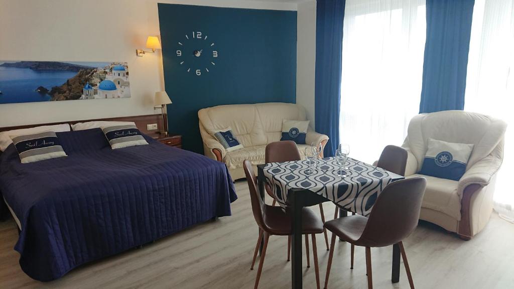 Apartament Santorini Kasprowicza 12A 440 في كولوبرزيغ: غرفة نوم بسرير وطاولة وكراسي