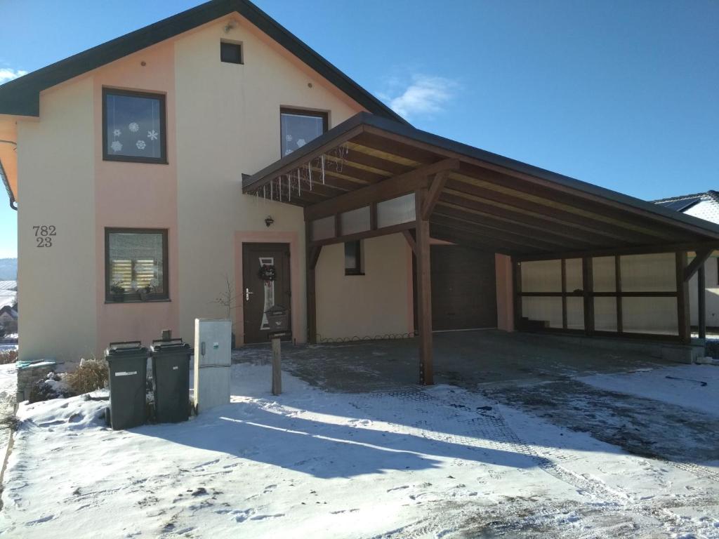 J&K Štrba في بوبراد: منزل في الثلج مع علبتين قمامة