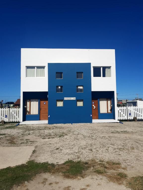 un bâtiment bleu et blanc devant une clôture dans l'établissement Cabañas Casazul, à Santa Clara del Mar