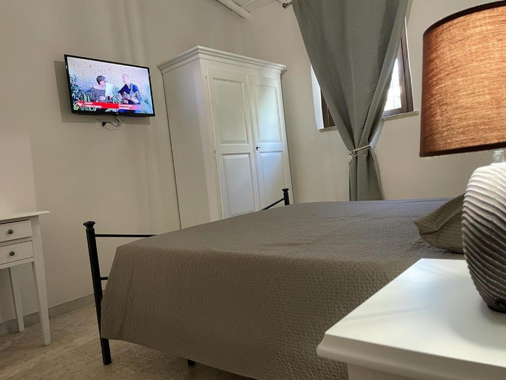 a bedroom with a bed with a tv on the wall at Il castagno in Vico nel Lazio