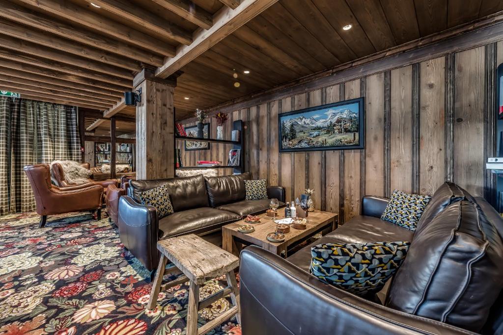 a living room with leather furniture in a cabin at Hotel & Spa Le Val d'Isère in Val-d'Isère