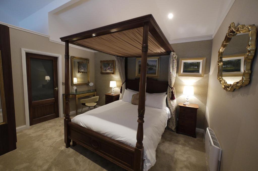 a bedroom with a canopy bed and a mirror at The Carriage Houses at Beechpark House in Bunratty
