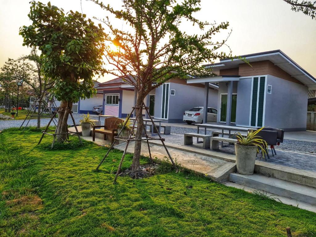 a house with two trees in front of it at Araya Cottage in Ban Bung Thap Tae (1)