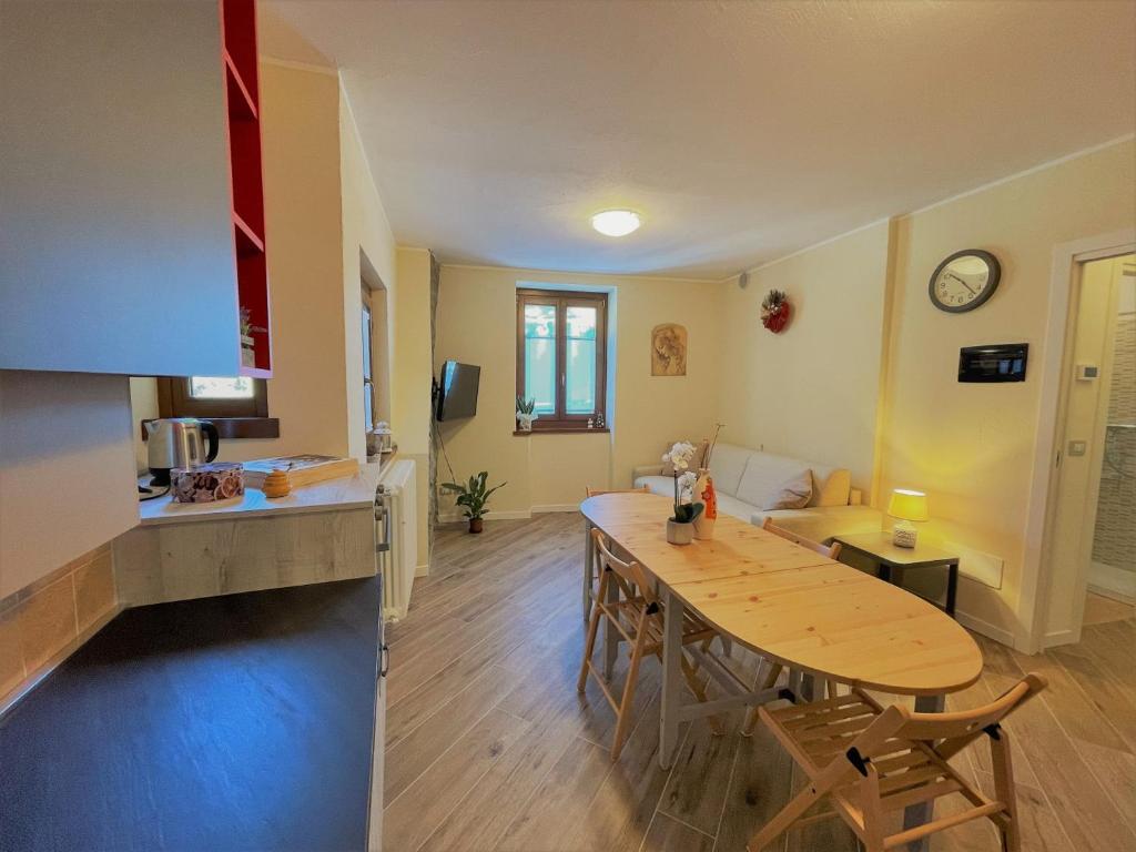 cocina y sala de estar con mesa de madera en Appartamento LaBaitaCase Contrada Pradella - Affitti Brevi Italia en Sondrio