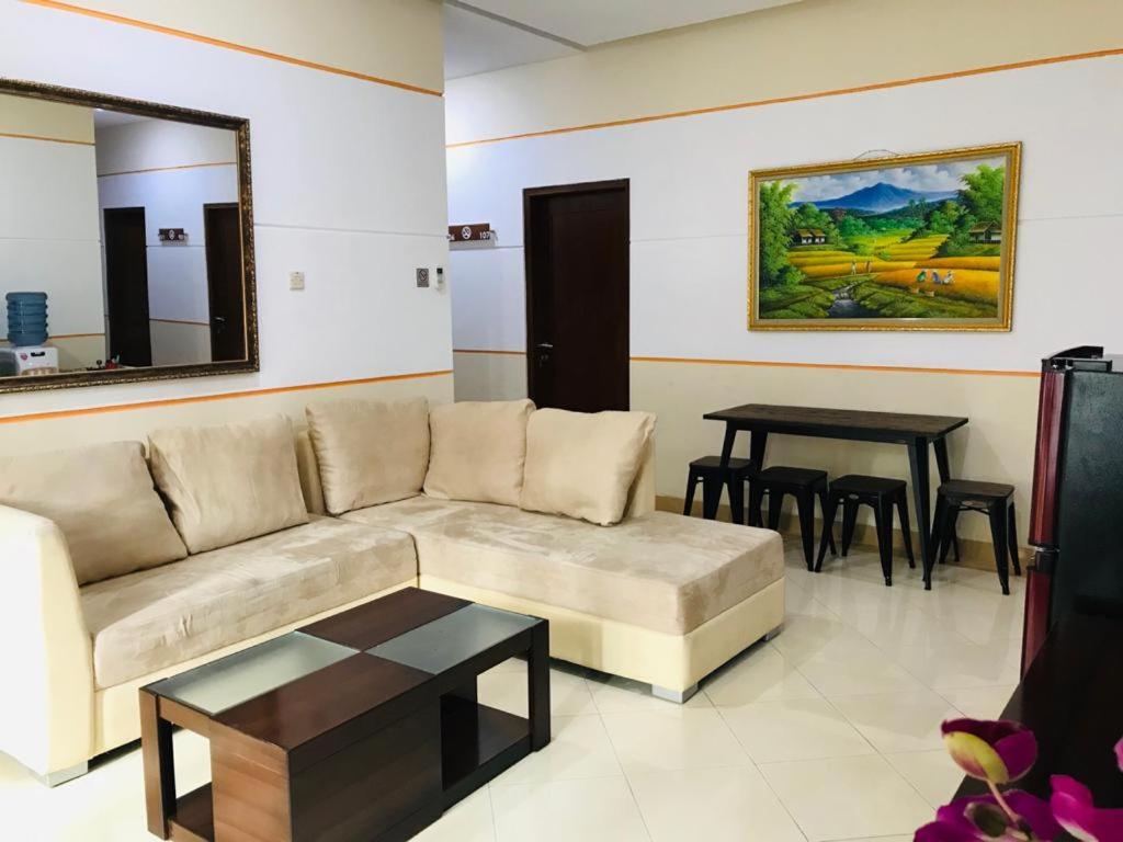 ein Wohnzimmer mit einem Sofa und einem Tisch in der Unterkunft Adiputra Guesthouse Tata Bumi in Ngabean