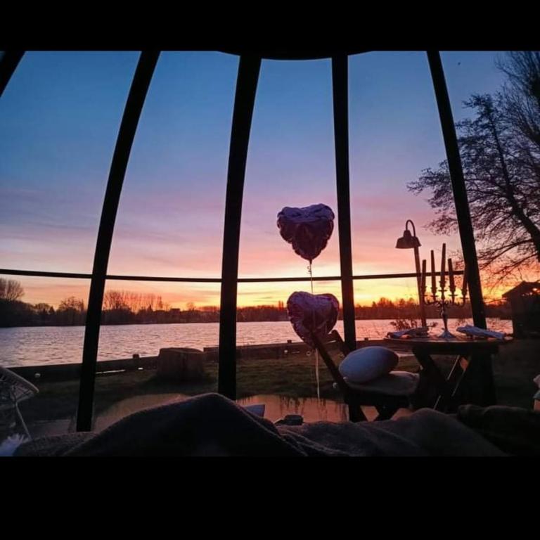 - une vue sur le coucher du soleil depuis une chambre dotée d'une table et de ballons dans l'établissement Le Dôme du Lac, à Ardres
