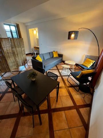 sala de estar con sofá y mesa en Chambre d'Aut' en Autun