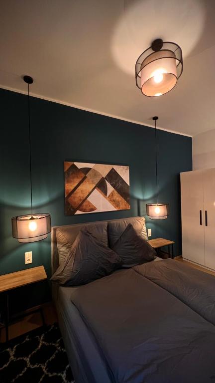 a bedroom with a bed with two lights above it at H-85 SUITES - BRIGHT Collection in Koblenz