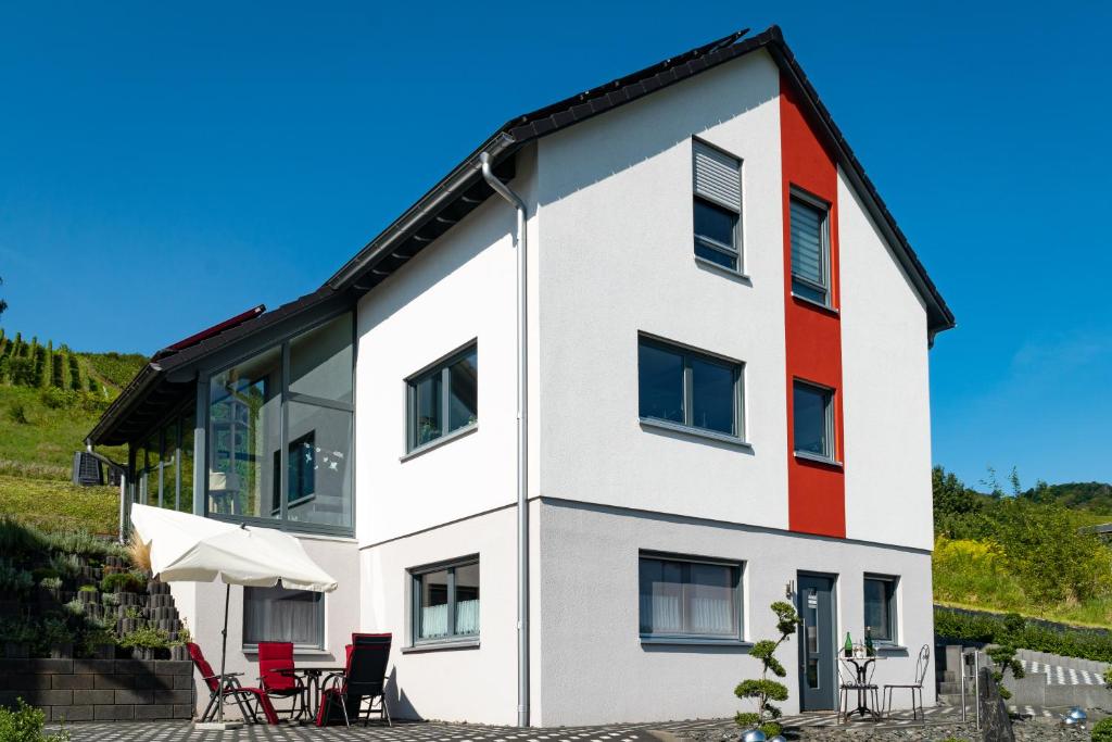 una casa de color rojo y blanco en Ferienwohnung "Schöne Aussicht" en Reil