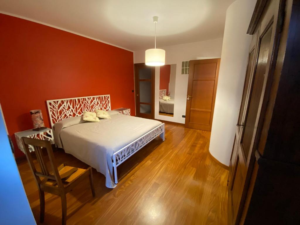 a bedroom with a white bed and a wooden floor at Il Ciapiné in Giaveno