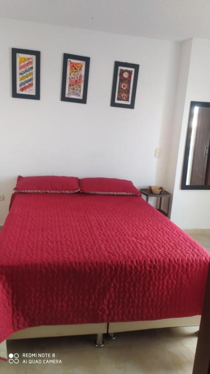 a red bed in a white room with a red bedspread at Apartamento 28U in Bucaramanga