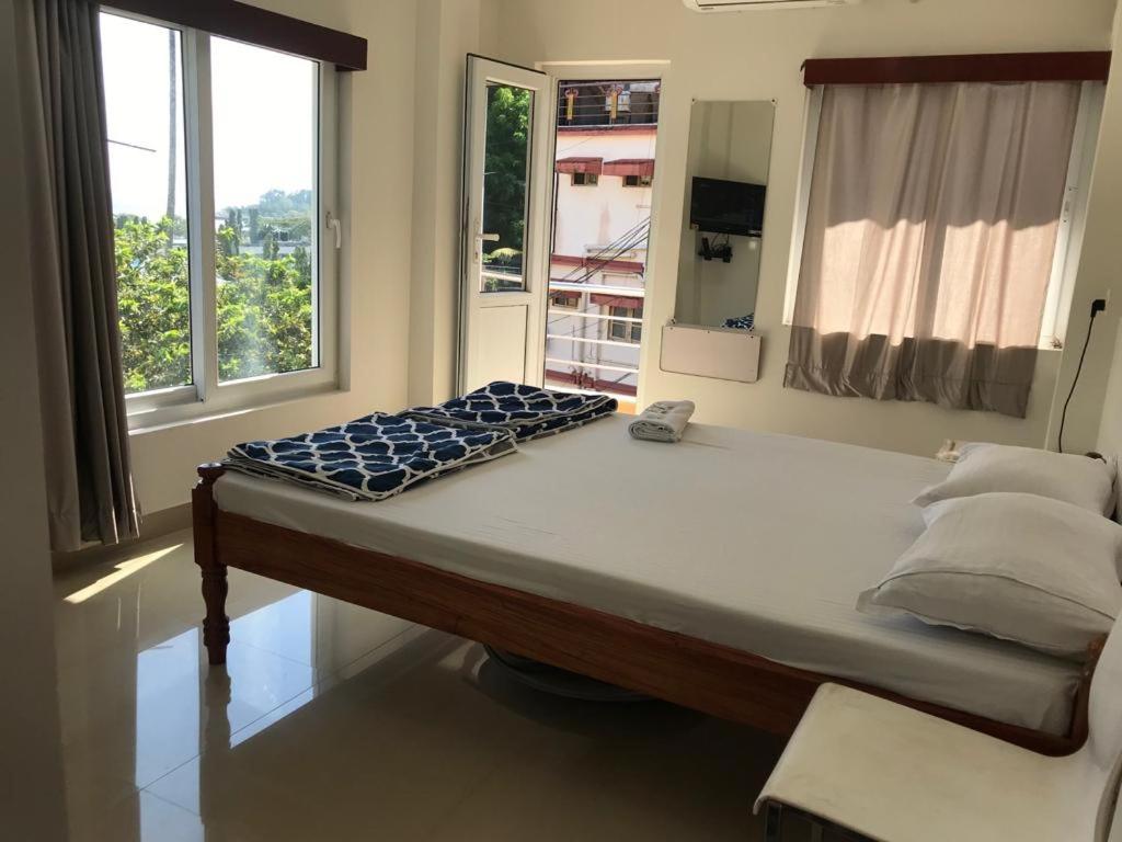 Andaman Vacations Home في ميناء بلير: سرير كبير في غرفة مع نافذة
