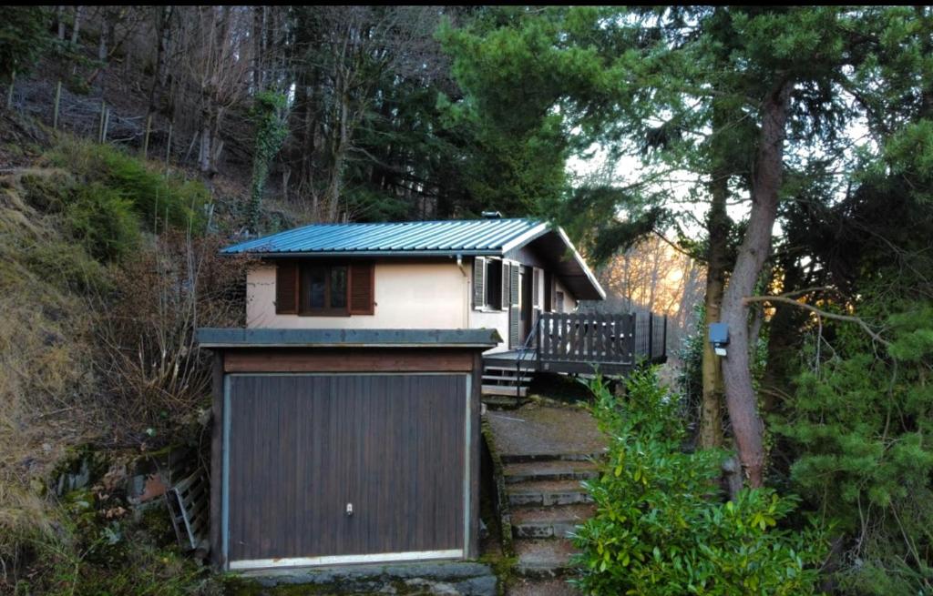 une petite maison avec un garage dans les bois dans l'établissement Le Balcon d’Echery, à Sainte-Marie-aux-Mines