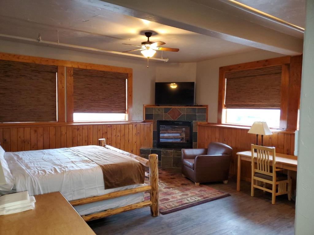 a bedroom with a bed and a chair and a fireplace at Buffalo Lodge of Bigfork in Bigfork