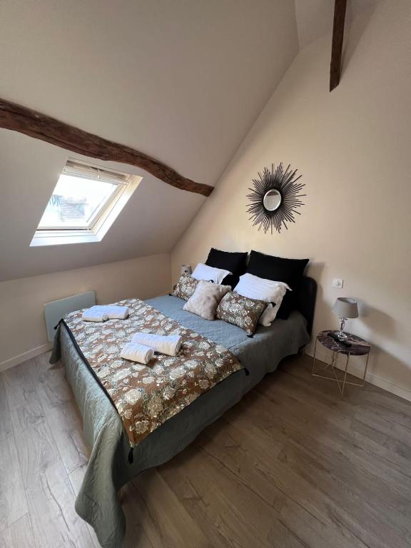 a bedroom with a large bed in a attic at Les Maisons d'Augustine, demeure de charme de la cour Ste Catherine in Honfleur