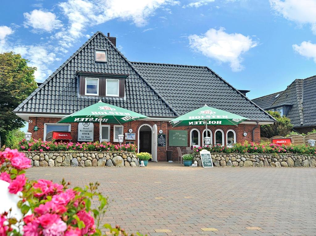 un bâtiment avec un panneau devant lui dans l'établissement Hotel und Restaurant Petit Robby, à Wenningstedt