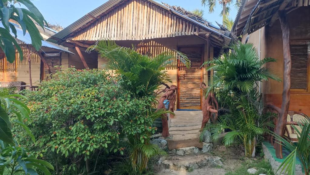 una casa con una porta in legno e alcune piante di Nature Beach Huts a Trincomalee