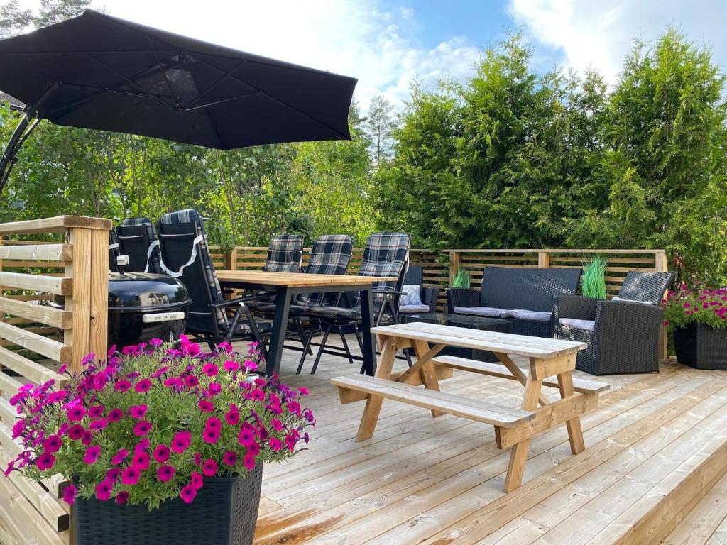 un patio con tavolo, sedie e griglia di Villa Movägen • Fast Free Wifi • AC • 10 min from lake a Mörlunda