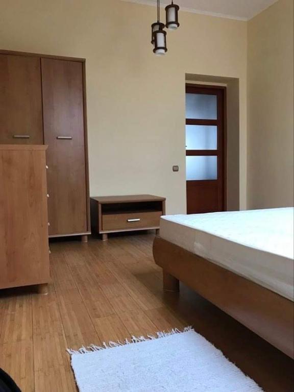 um quarto com uma cama, uma cómoda e uma porta em Затишна квартира в спальному районі em Lviv