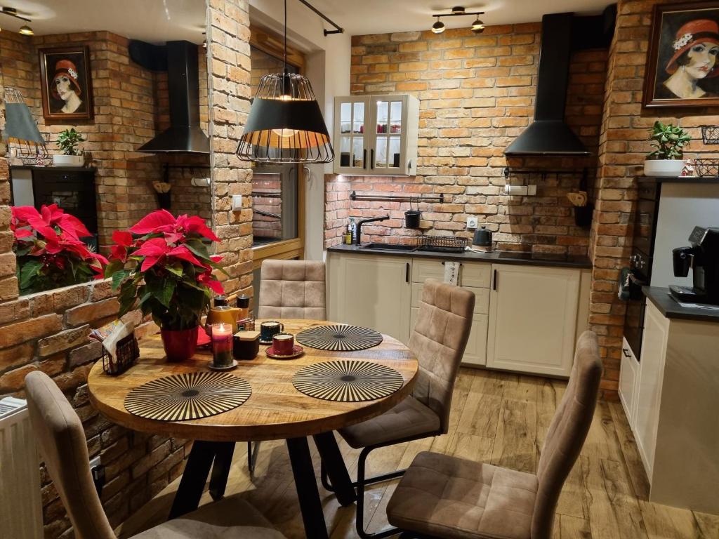 cocina y comedor con mesa de madera y sillas en APARTAMENT nad MOTŁAWĄ LUŚKA en Gdansk