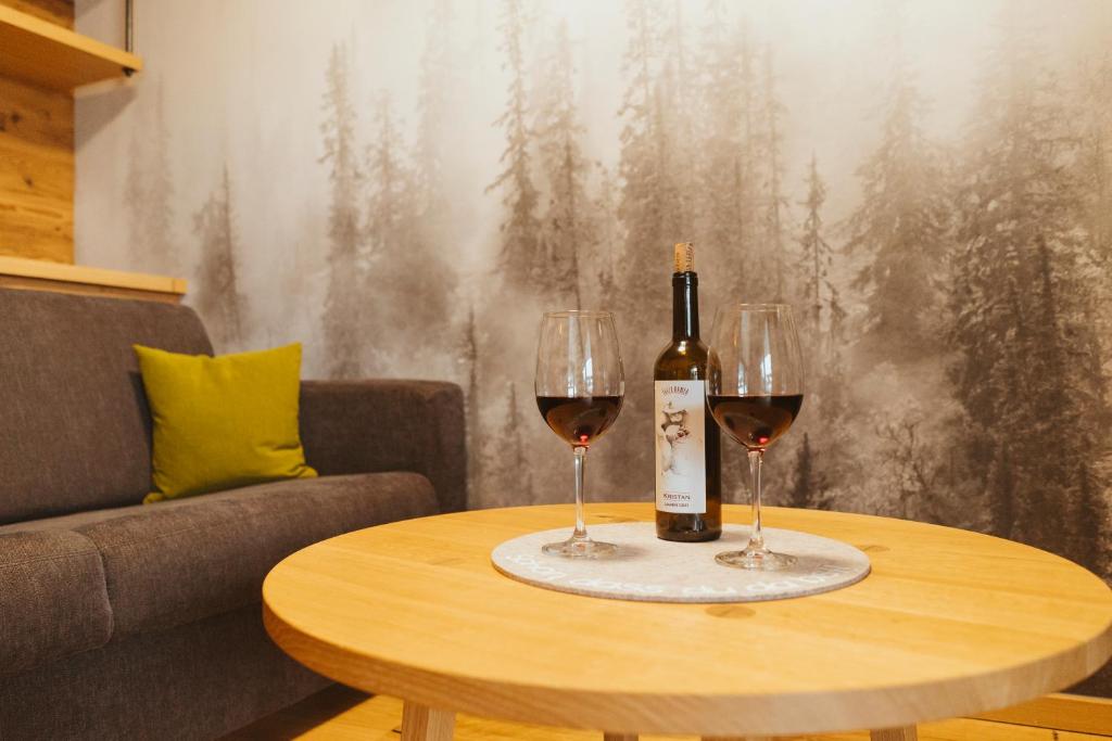 Ferienwohnung am Dorfbach في ريتينبيرغ: طاولة مع كأسين من النبيذ وزجاجة من النبيذ