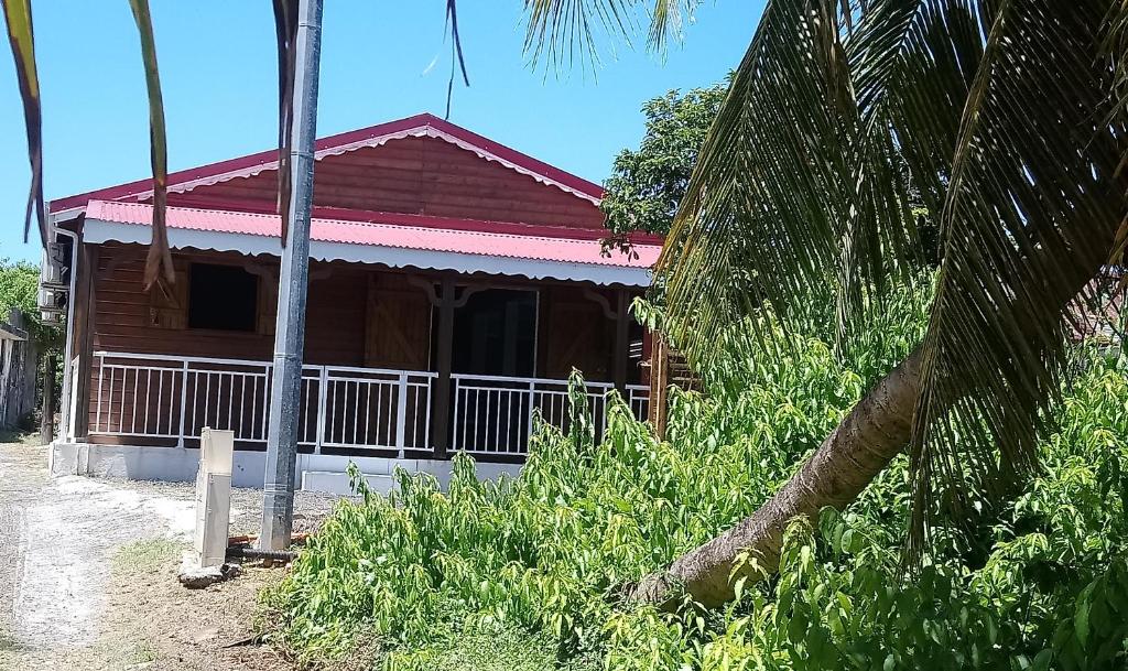 a wooden house with a red roof at LABéKAZ’KRéYòL in Le Moule