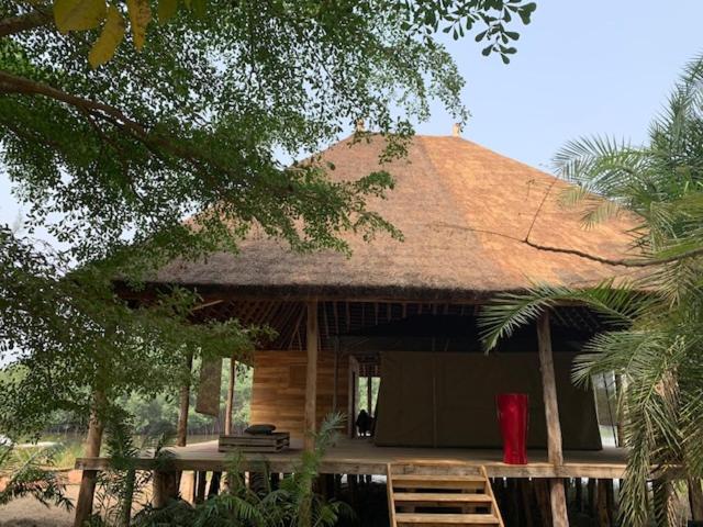 OuidahにあるNatura Luxury Lake Hutの茅葺き屋根の大小屋