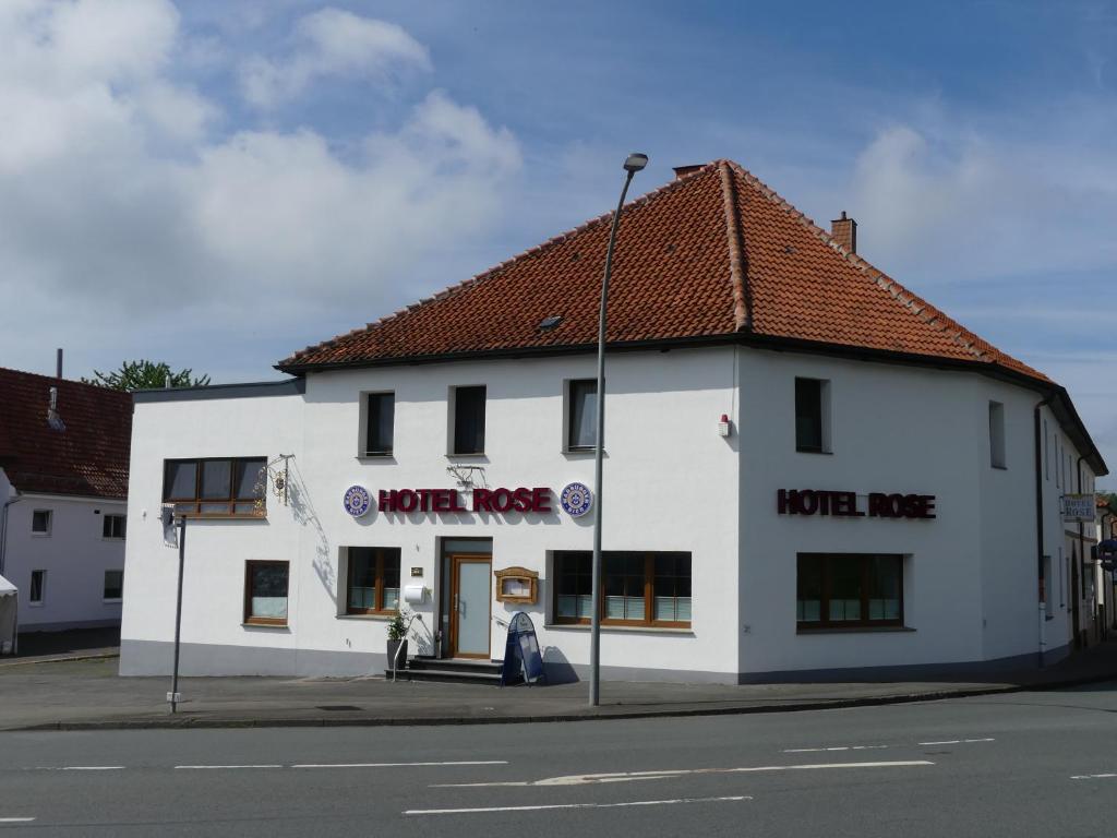 a white building on the corner of a street at Hotel Rose in Warburg