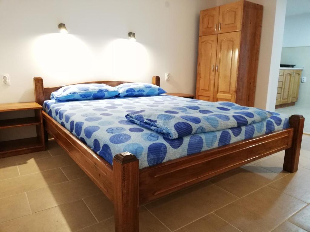een slaapkamer met een bed met een blauw dekbed bij Sobe i apartmani Simic in Ribarska Banja