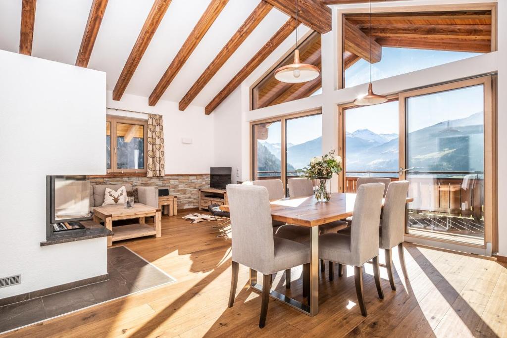 a dining room with a table and chairs and a fireplace at Chalet-Appartement mit Penthouse Flair in Bad Hofgastein
