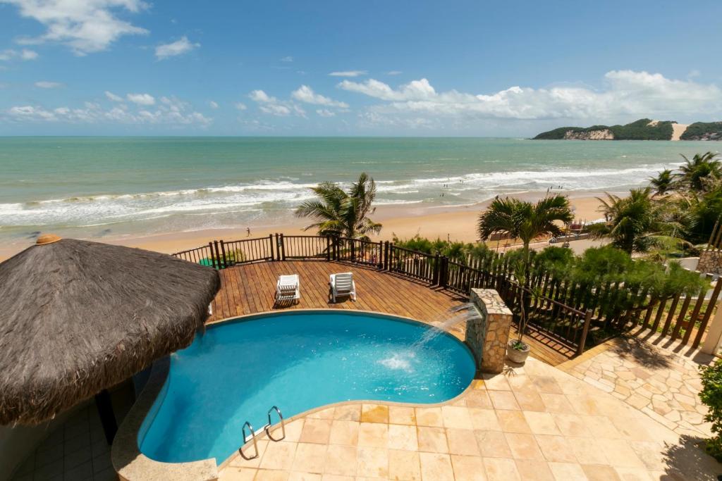 a swimming pool with a view of the beach at Residence Vespucci in Natal