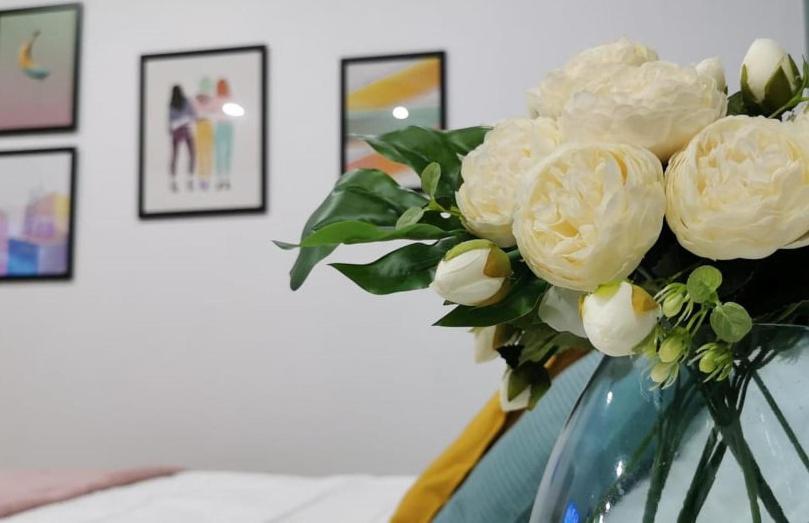 a vase filled with white roses in a room at Pretty and quiet studio, with wifi and parking in Limassol