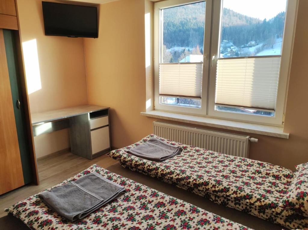 A bed or beds in a room at Apartamenty As Szczyrk Centrum