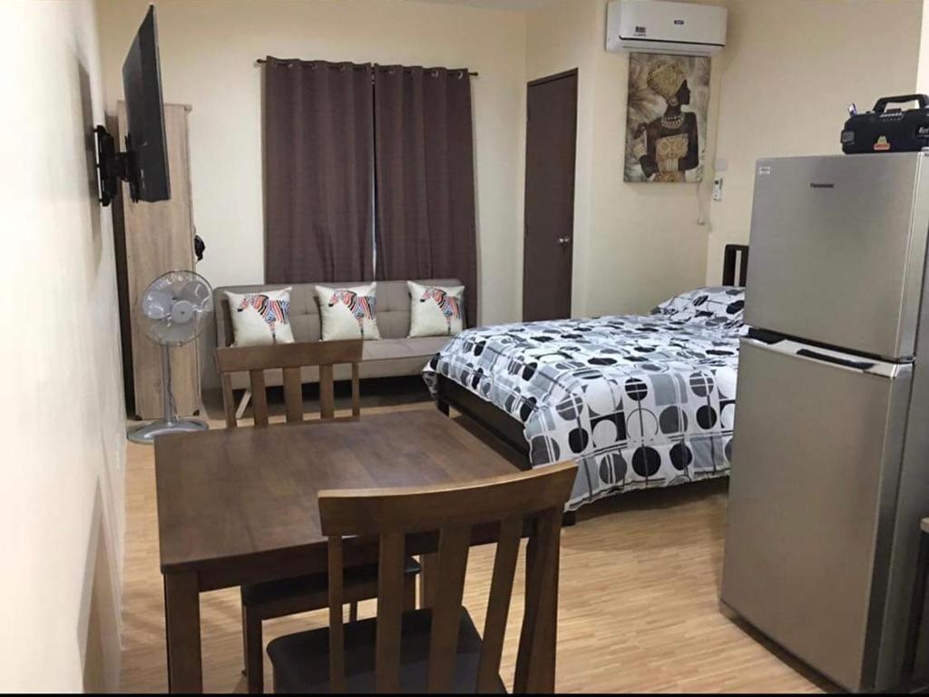 een kamer met een bed, een tafel en een koelkast bij FRANK CRIB in Cagayan de Oro