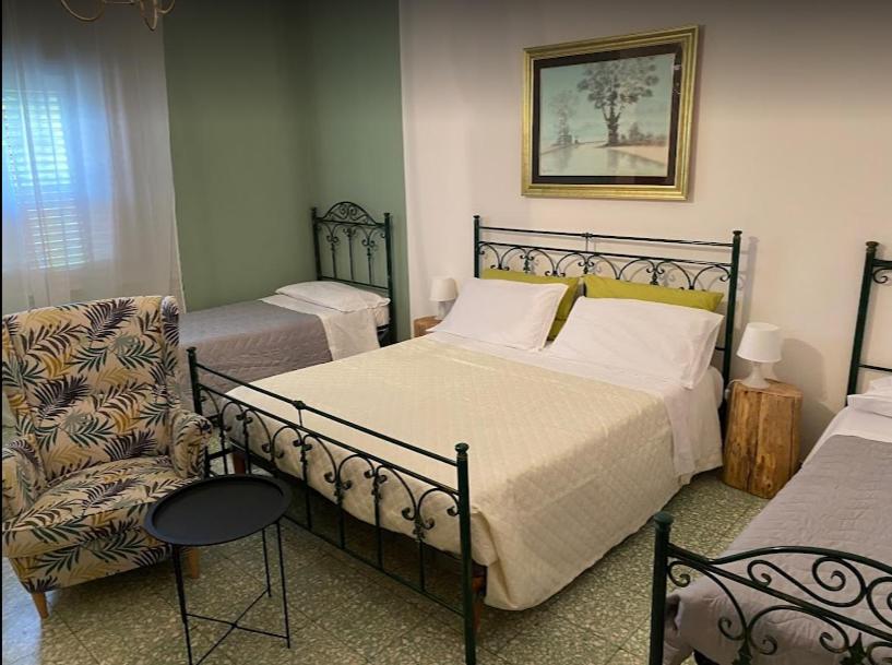 a bedroom with two beds and a chair and a bed and a picture at B&B Al Cavaliere in Lorica