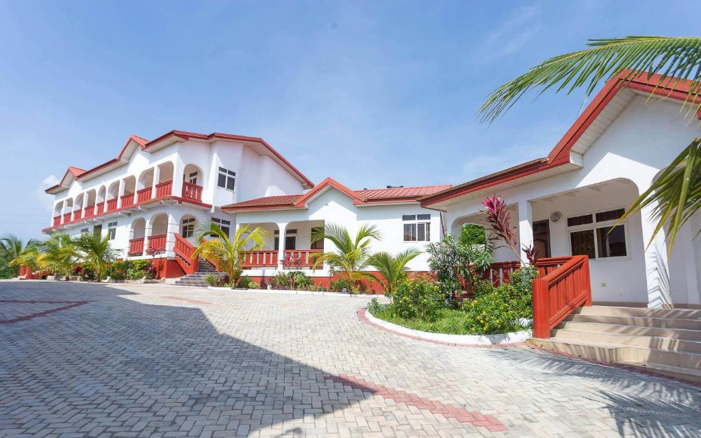 una gran casa blanca con entrada en Royal Elmount Hotel, en Elmina