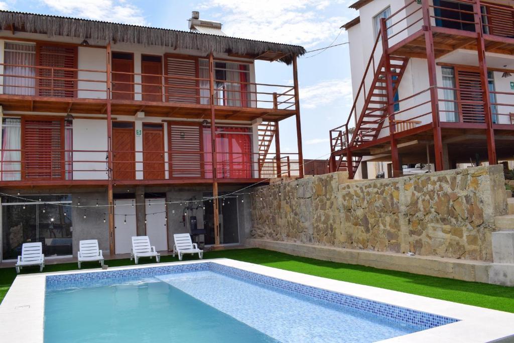 a house with a swimming pool in front of a building at Mangata in Lobitos