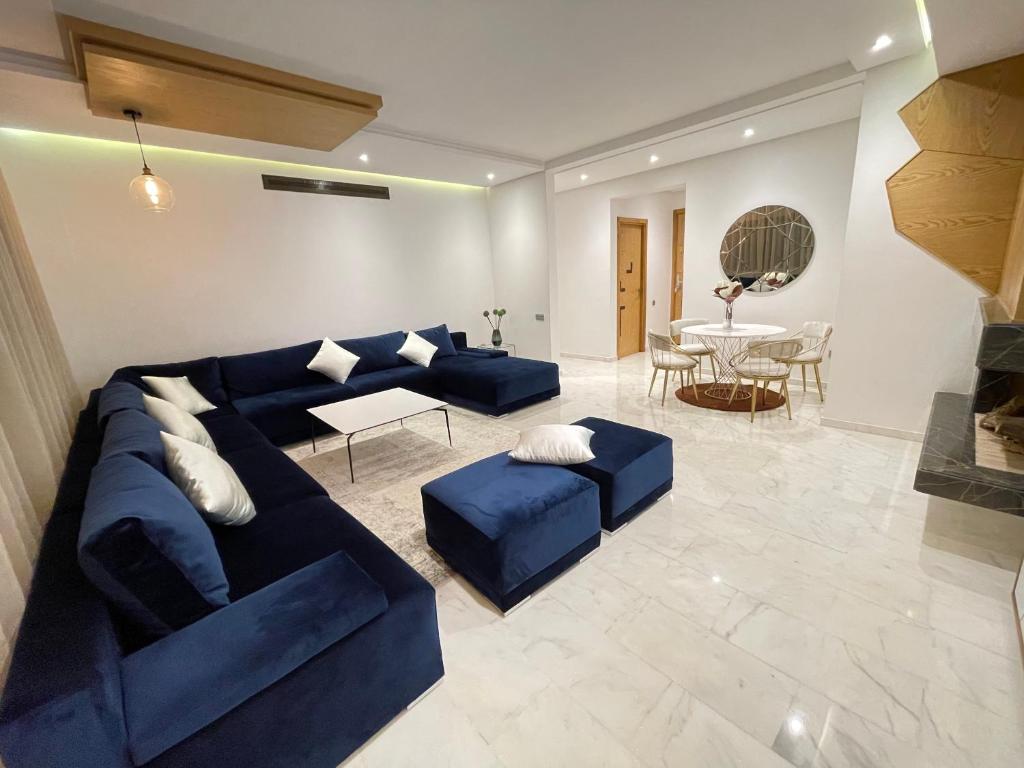 a living room with a blue couch and a table at NEW SUPER LUXURY APARTMENT (CENTRAL MARRAKECH) in Marrakesh