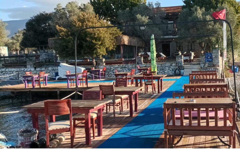 eine Gruppe von Tischen und Stühlen neben einem Wasserkörper in der Unterkunft KAPTAN HAN Boutique hotel in Kazıklı