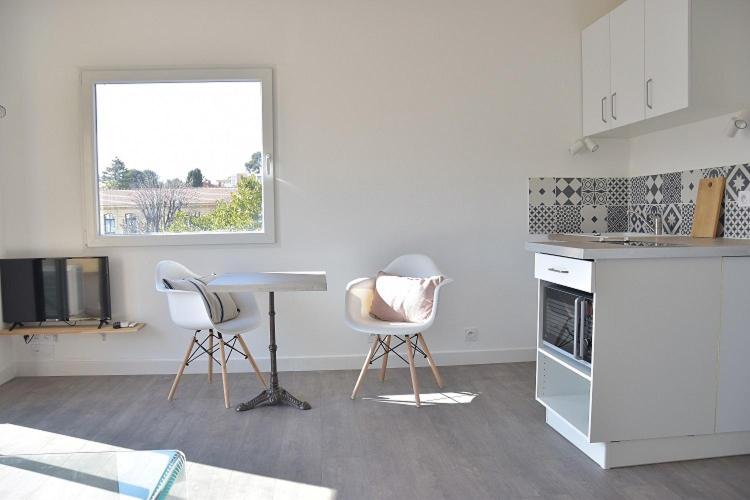 une cuisine avec deux chaises, une table et une fenêtre dans l'établissement PETIT LOFT Antibes, à Antibes