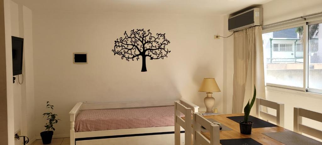 ein Schlafzimmer mit einem Baumstenrat an der Wand in der Unterkunft PASAJE EN EL CENTRO DE LOMAS in Partido Lomas de Zamora