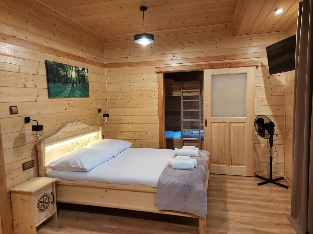 a bedroom with a bed in a wooden room at Pokoje gościnne u Galusia in Mochnaczka Wyżna